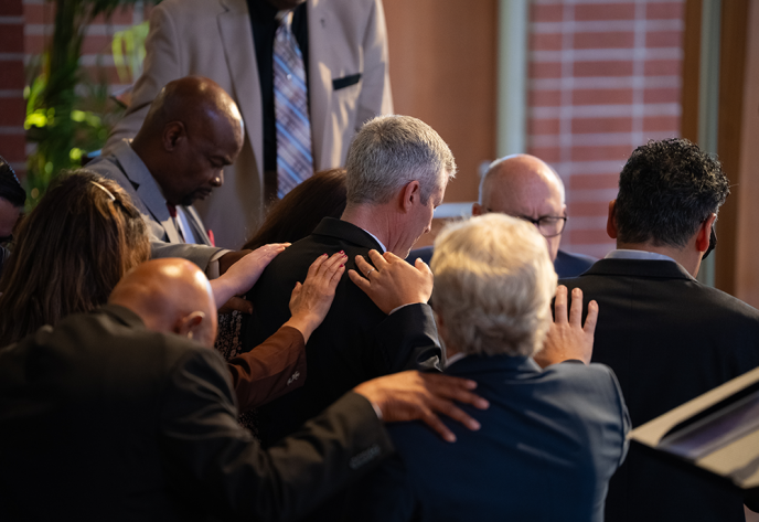 SCC Executive Secretary Danny Chan offers the ordination prayer as ordained ministers in attendance lay hands on Sewell and his wife.