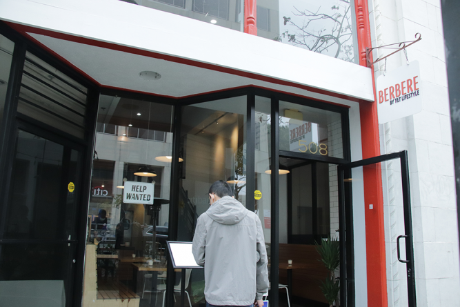 A passerby stops to look at Berbere's menu posted outside of the restaurant.