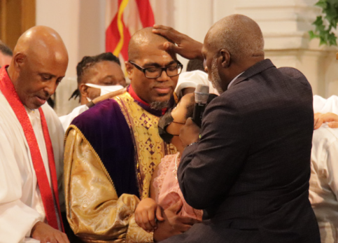 Elder Donavan's father, Virgil Childs, anoints his head with oil and offers the ordination prayer.
