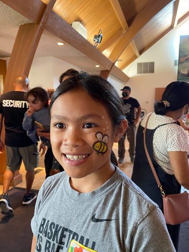 One child shows her face painting.