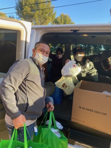Volunteer Marjury Agagas helps load the van with breakfast platters in reusable grocery bags.