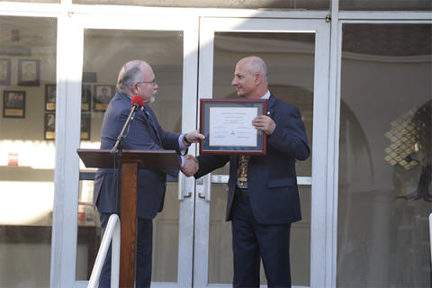 John H. Cress, SCC executive secretary, (left) presents Khachatryan (right) with the certificate of company status.