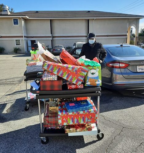 Pastor Trusty delivers wrapped gifts to the San Fernando Valley Salvation Army.
