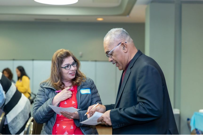 Attendees greet one another through an ice-breaker activity. Approximately 160 people attended the training both days.