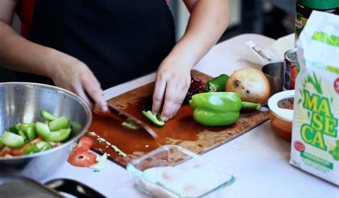 Oneida Perez-Rivera shares from her Guatemalan background while she mixes chiles, peppers, garlic, and onion to make a sauce for the chuchitos.