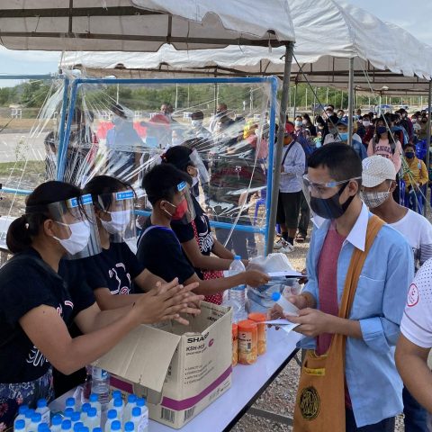 Students distribute Vitamin C, NEWSTART pamphlets, mask, and hand sanitizer to migrant workers at the second friendship bridge after workers have been processed and head to cross the border.