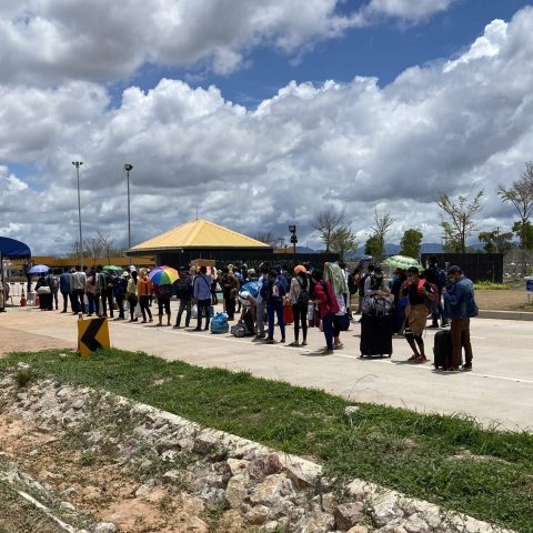 Migrant workers line up at the border gate as they are lead from the Thailand side of the border to the Myanmar side to be processed by the Myanmar government.