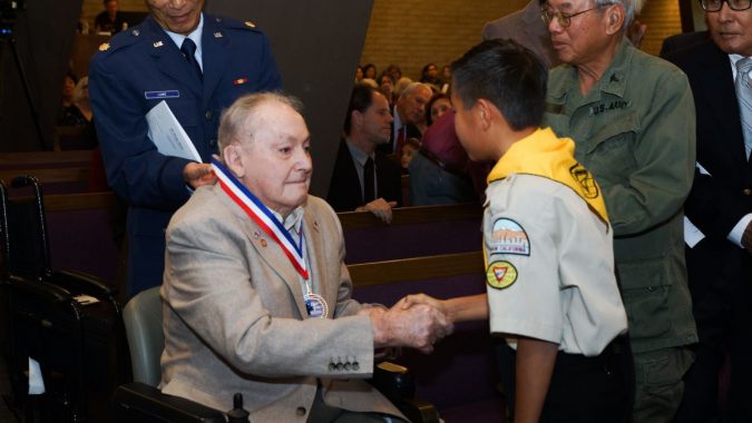 A Pathfinder thanks WWII veteran Walter Easley after placing a medallion around his neck. Each veteran received a specially minted medallion for the occasion. Photos by Danny Syto.