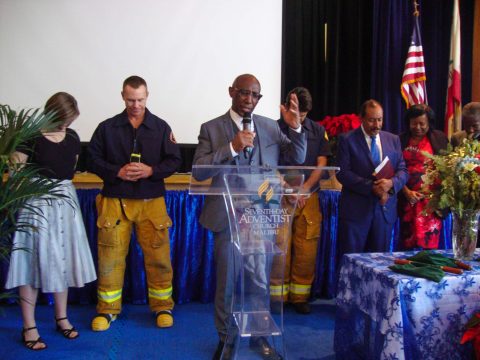 Jeffrey Brown, associate secretary of the General Conference Ministerial Association, prays over the firefighters and attendees with December birthdays. Photos by Connie Jeffery.