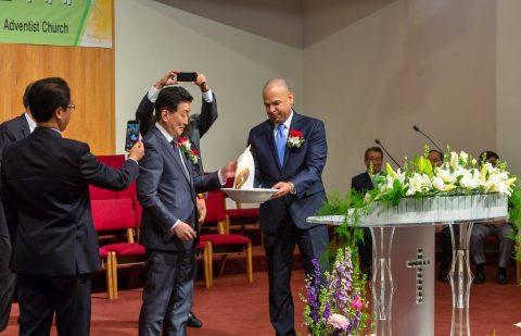 Orville Ortiz, SCC treasurer/ CFO (right) burns the mortgage document. Photos provided by Young Rin Kim.