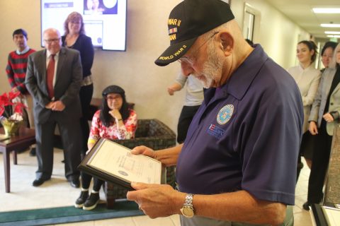 ESGR volunteer and WWII veteran Ernest Cowell presents the last award to the president as SCC office staff look on.