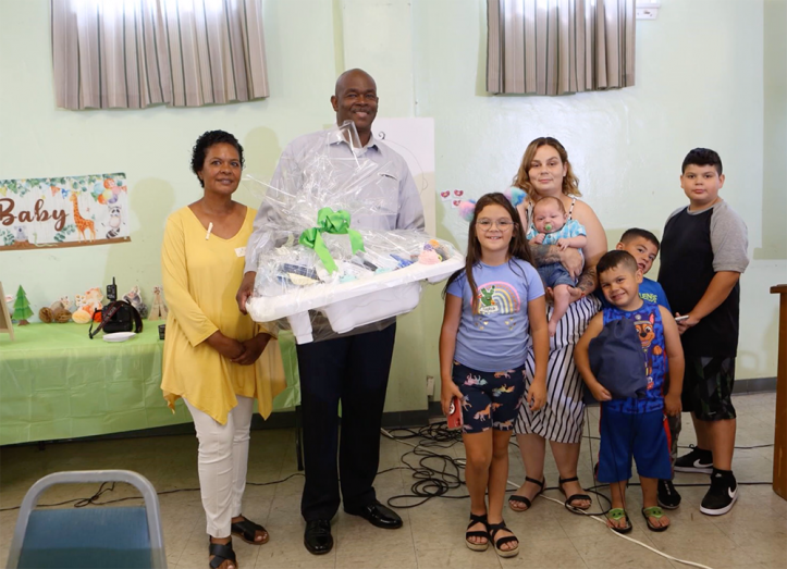 All moms in attendance received a gift basket filled with necessities. Here, pastor and Mrs. Johnson (far left) present a gift basket to one family. 