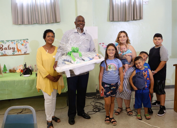 All moms in attendance received a gift basket filled with necessities. Here, pastor and Mrs. Johnson (far left) present a gift basket to one family.