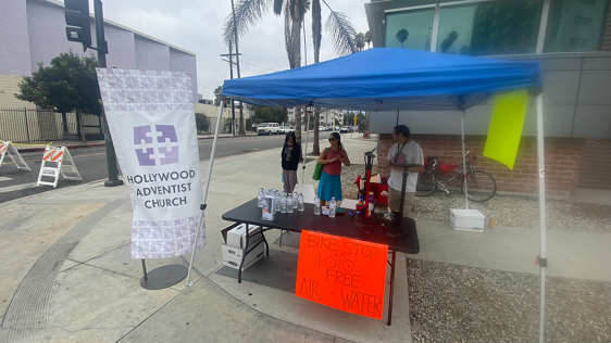 Volunteers stand by their bike stop
advertising free water and air. The Hollywood church building did
not have the required four feet of sidewalk space, so the tent was set up in front of the fire station on the opposite corner of the church.