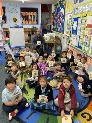 Flores is pictured with the kindergarten class for the reading of his self-published book, The First Man on Earth: A Creation Story.