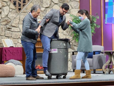 During his message, entitled “Lord, I Will Go! Free Me,” Garcia (center) demonstrates the power of temptation by at first resisting, then climbing into a trash can—and the difficulty that may come with getting stuck.
