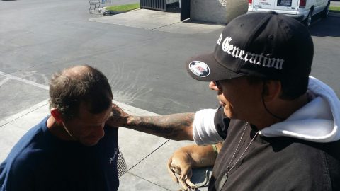 Hill prays with homeless man in Skid Row in Los Angeles. Photos provided by Holly Anderson.