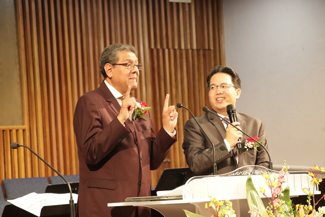 Salazar (left) preaches while Choe (right) translates.