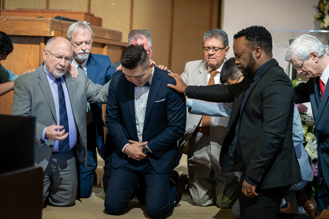 Ordained pastors in attendance lay hands on Park as Cress offers the ordination prayer.