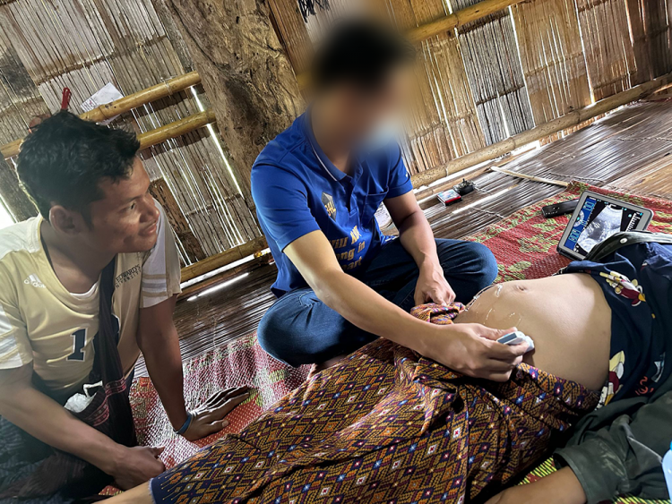 The doctor performs an ultrasound for a pregnant patient while
the expectant father looks on.