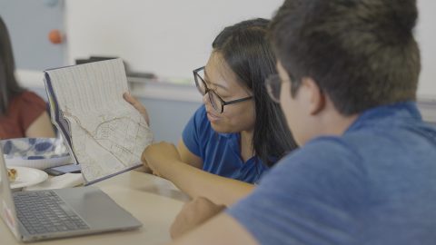 Oreño (left) shows Youth Rush leader Joshua (right) a map of neighborhoods for their route.