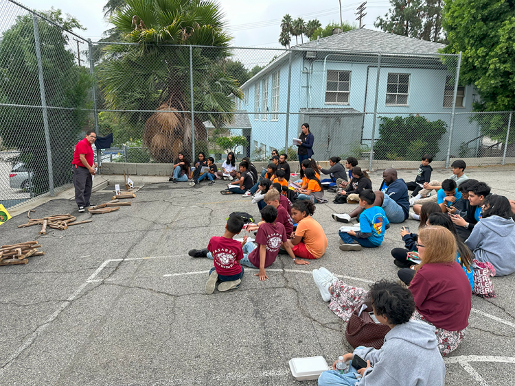 JJ Martinez (left) teaches an outdoor class on fire building and camp cookery.