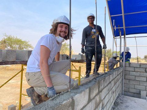 Volunteers offer smiles amid the physically demanding job of laying block walls.