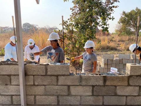 Even the group's younger volunteers work hard, laying mortar between blocks.