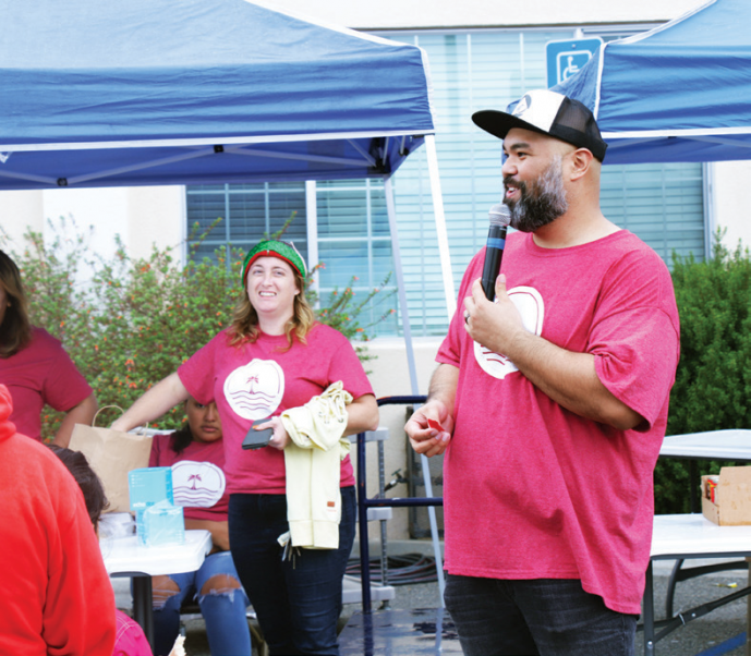 Lopez (right) announces the final giveaways before offering a closing prayer over those in attendance.