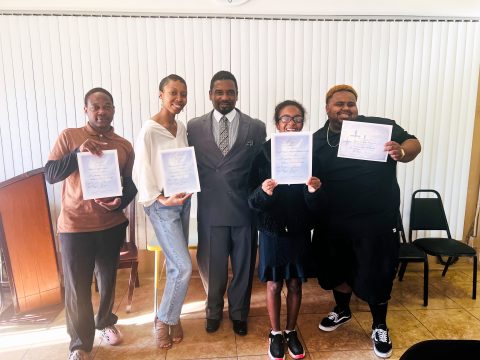 The newly baptized members display their baptism certificates. Left to right: Michael Lewis, Hannah Render, Pastor Roger Frazier, Zhaniah Tamplin, and Miles Frazier.