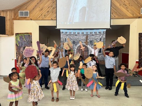 Children learn about the armor of God, using shields, belts, and swords made of cardboard, during a children’s Sabbath program in June.