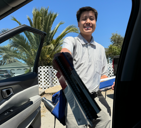 Joseph shows the six-book set a man just received at a door.